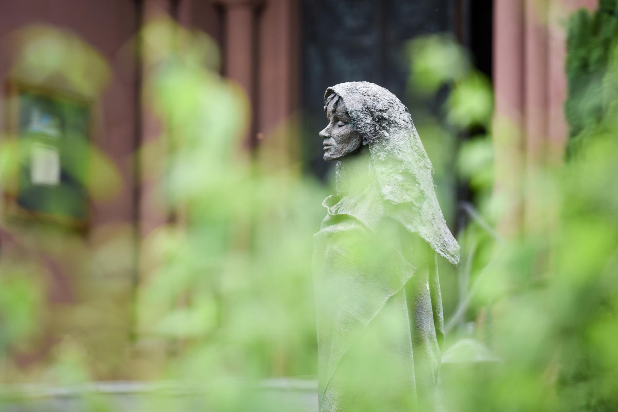 Eine Figur von Hildegard von Bingen steht im Klostergarten der Benediktinerinnenabtei Sankt Hildegard in Rüdesheim.